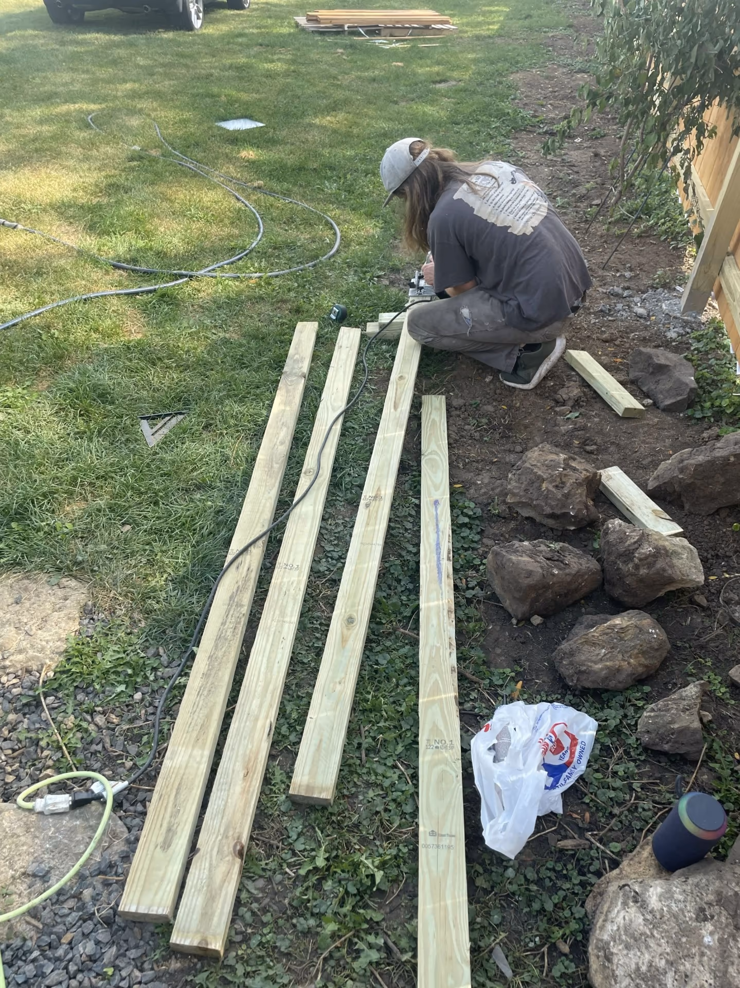 Fence installation — cutting pressure-treated lumber on site